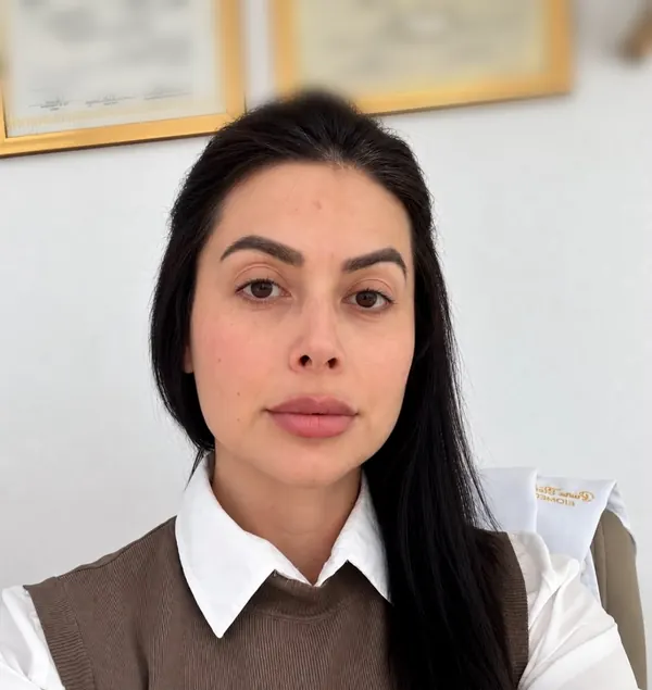 Dra. Bruna Stolk Mariot no consultório, com os diplomas de Biologia e Biomedicina na parede